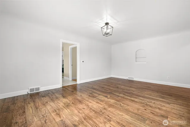 a view of a room with wooden floor and a ceiling fan