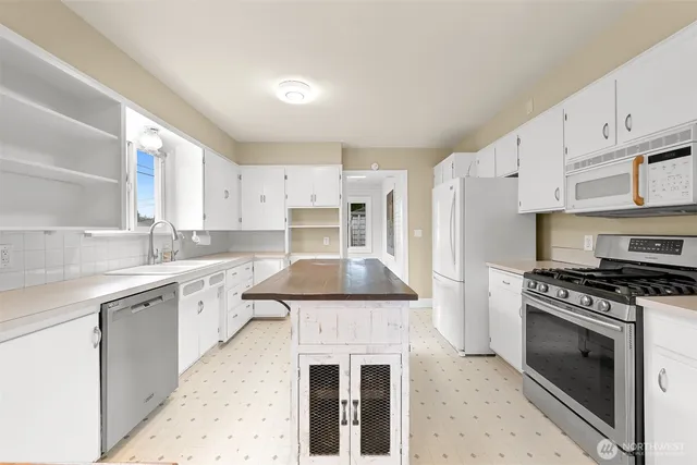 a kitchen with granite countertop a stove sink and cabinets