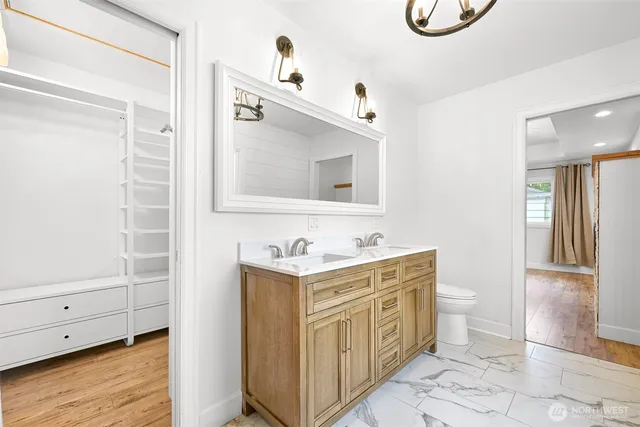 a bathroom with a sink a toilet and a mirror