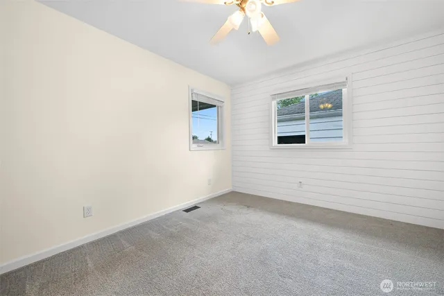 an empty room with a chandelier fan