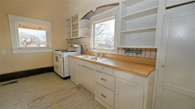 a kitchen with a sink cabinets appliances and a window