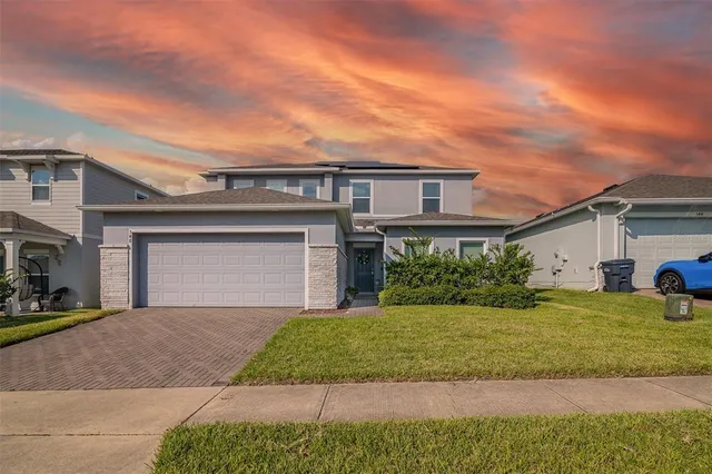a front view of a house with a yard and garage