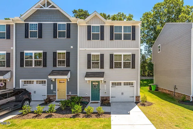 a front view of house with yard and trees in the background