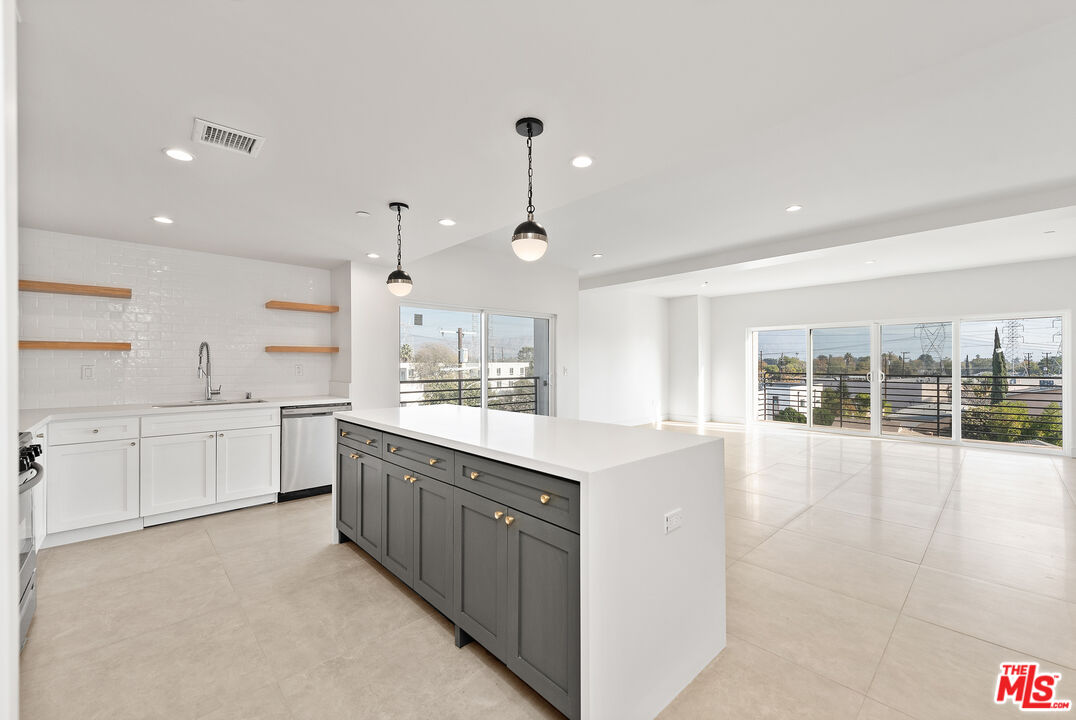 a large kitchen with kitchen island white cabinets and wooden floor