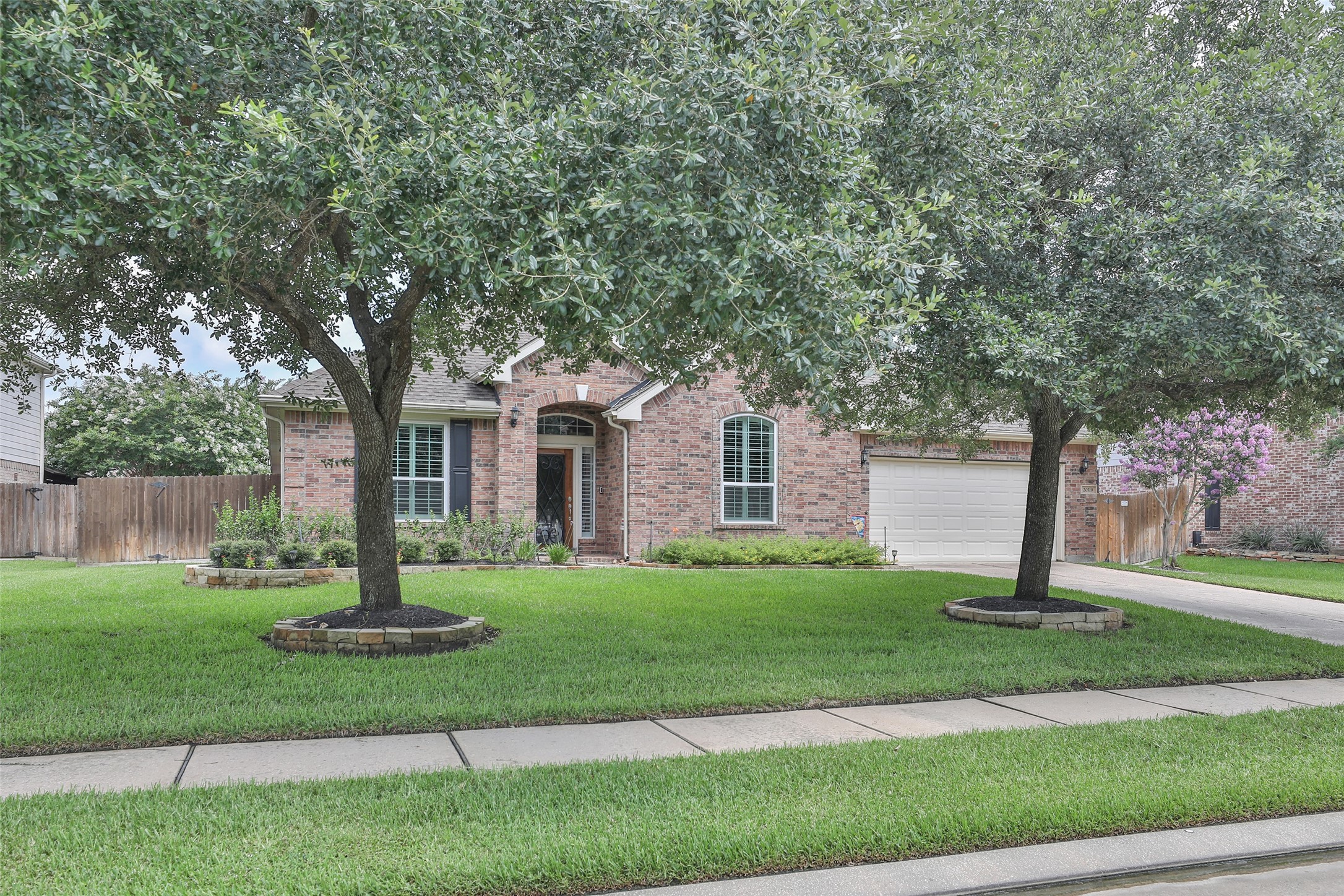 20519 Windrose Bend Drive Spring, TX 77379 - Photo 2 of 37 Enjoy the exceptional curb appeal of this beautiful brick elevation, featuring an extended driveway, mature trees, and meticulously maintained lawn and landscaping.
