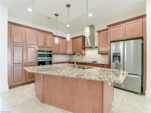 a kitchen with stainless steel appliances granite countertop a refrigerator and a sink