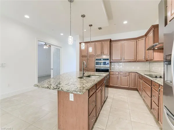 a kitchen with stainless steel appliances granite countertop a sink stove and cabinets