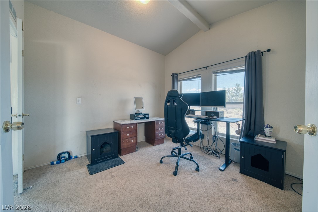 2931 Rio Rancho Drive, Unit 4 Pahrump, NV 89048 - Photo 12 of 21 A versatile home office offers vaulted ceilings, soft carpet, and a broad window with scenic outdoor views.