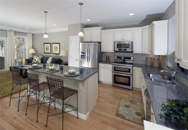 a kitchen with stainless steel appliances granite countertop a stove a sink a microwave a refrigerator and chairs