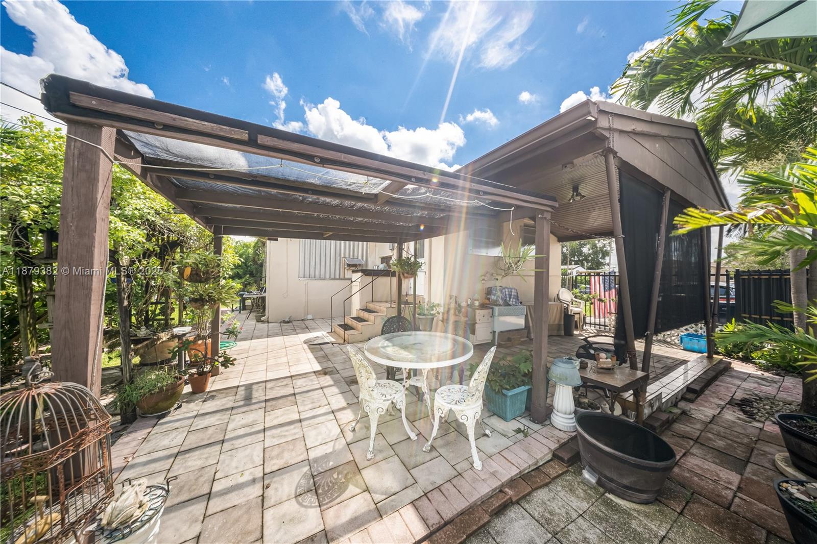 8341 Southwest 27th Lane Miami, FL 33155 - Photo 16 of 20 a view of a patio with table and chairs potted plants with floor to ceiling window and potted plants