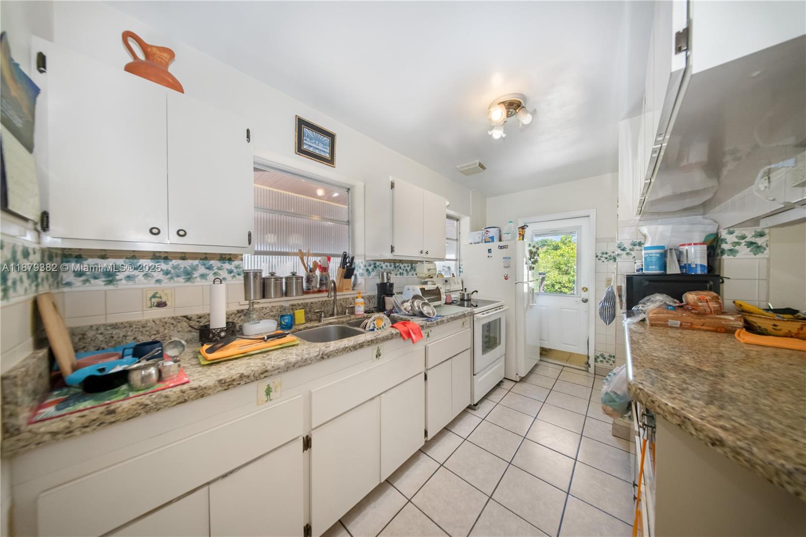 8341 Southwest 27th Lane Miami, FL 33155 - Photo 8 of 20 a kitchen with a sink stove and cabinets