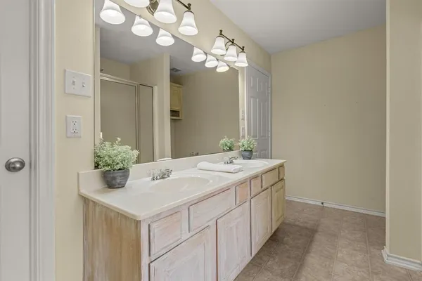 a bathroom with a sink a large mirror and a chandelier