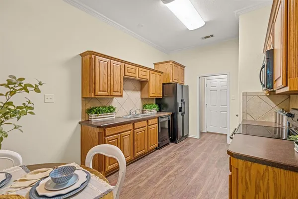 a kitchen with stainless steel appliances granite countertop a sink and wooden cabinets