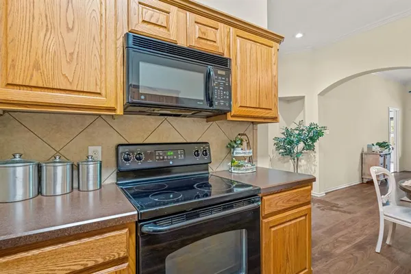 a kitchen with granite countertop a stove a sink and a microwave