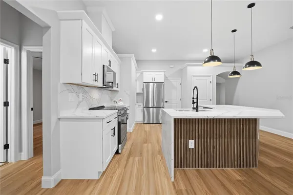 a kitchen with kitchen island a sink stainless steel appliances and cabinets