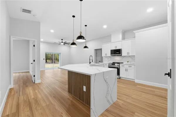 a kitchen with a sink a counter top space and stainless steel appliances