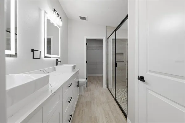 a bathroom with a double vanity sink a mirror and a bathtub