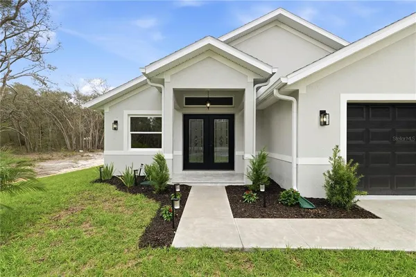 a front view of a house with a yard outdoor seating and garage
