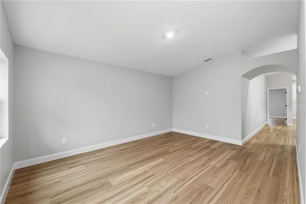 a view of an empty room with wooden floor