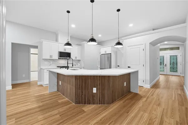 a kitchen with kitchen island a sink and wooden floor