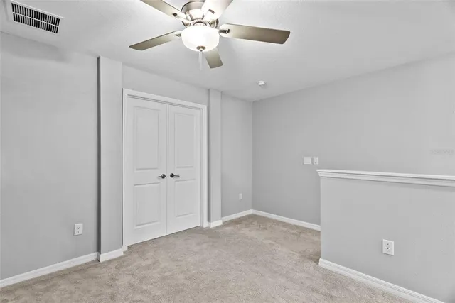 a view of an empty room with a ceiling fan