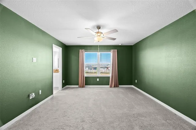 a view of a room with a ceiling fan and a window