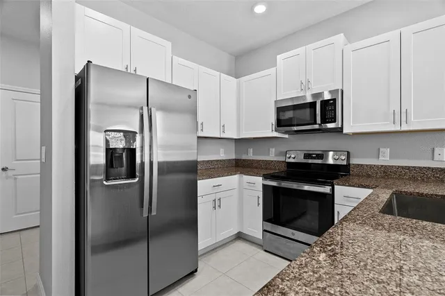 a kitchen with stainless steel appliances granite countertop a sink stove and microwave