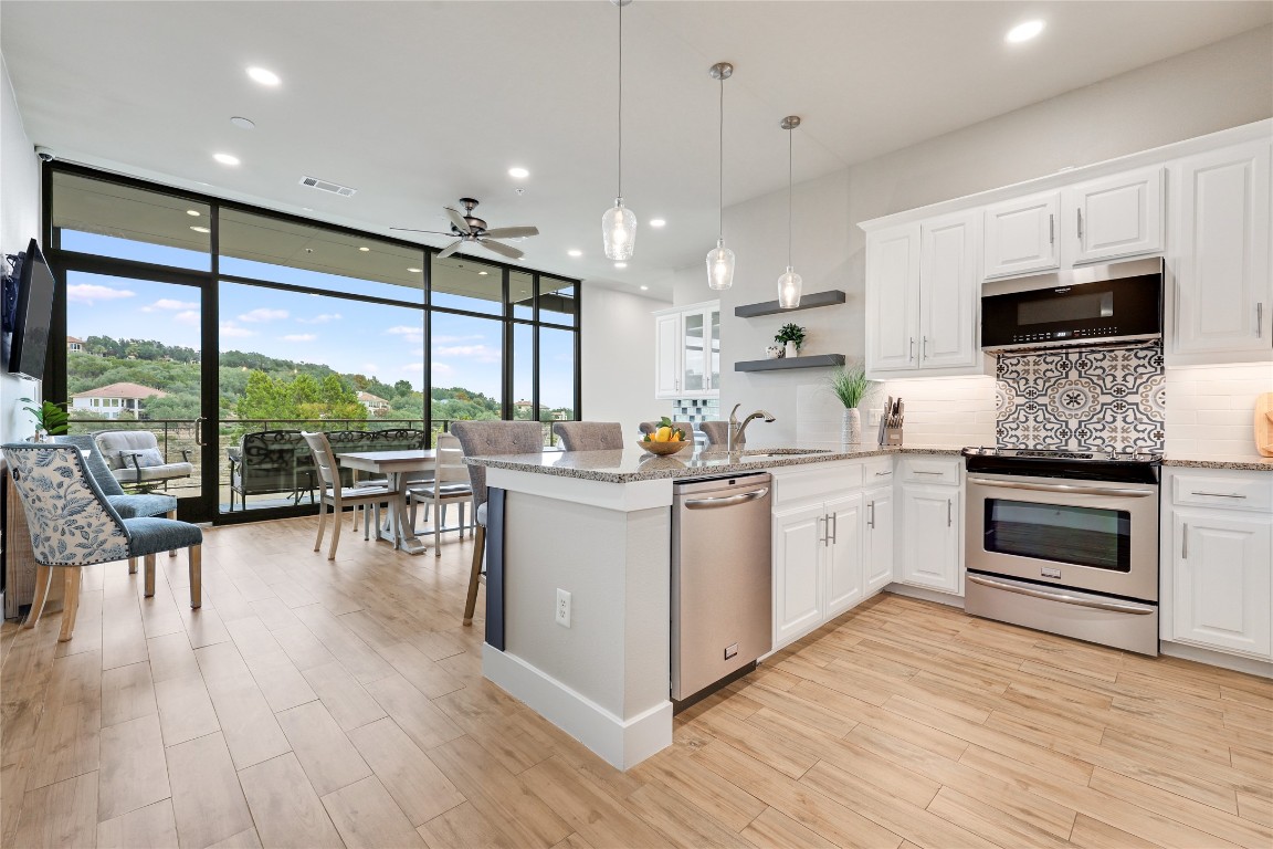 1101 Ivean Pearson Road, Unit B103 Lago Vista, TX 78645 - Photo 16 of 39 a kitchen with a table chairs stove and cabinets