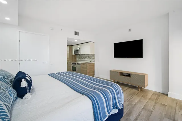 a bedroom with a bed and a flat screen tv