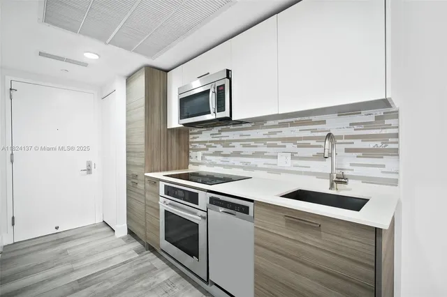 a kitchen with stainless steel appliances granite countertop a stove and a microwave