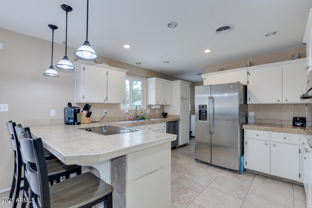 4215 West Dailey Street Phoenix, AZ 85053 - Photo 13 of 32 a kitchen with refrigerator cabinets and chairs