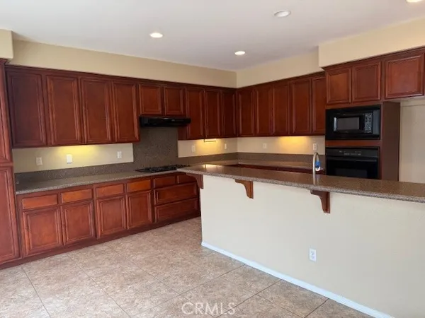 a kitchen with a sink a counter and chairs