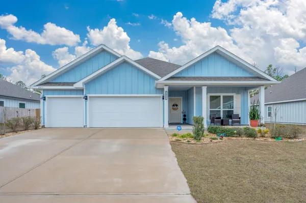 a view of a house with a yard and potted plants