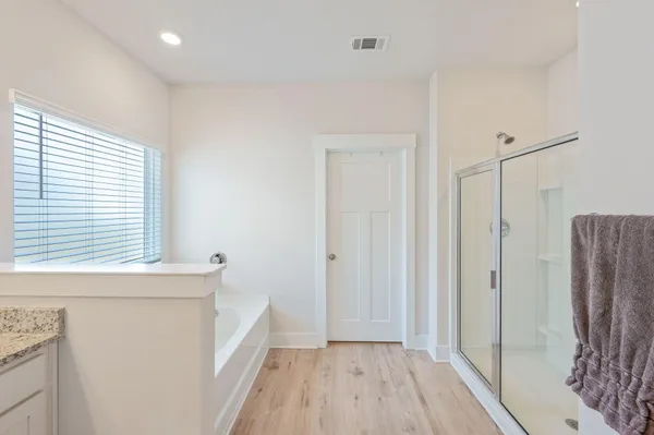 a view of hallway with a large window and wooden floor