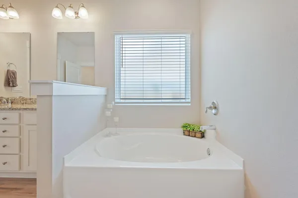 a white bath tub sitting in a bathroom next to a window
