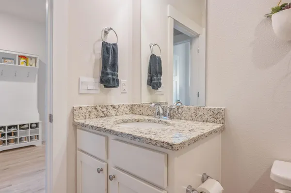 a bathroom with a granite countertop sink and a mirror