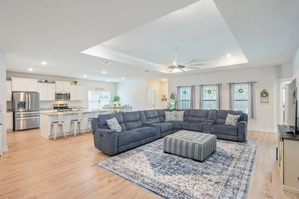 a living room with furniture and view of kitchen