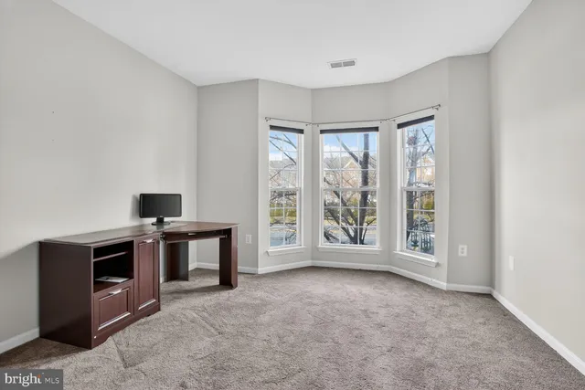 a view of kitchen with stainless steel appliances wooden floor and window
