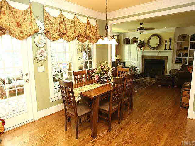 8810 Fidelis Lane Raleigh, NC 27613 - Photo 5 of 10 a dining room with furniture a fireplace and wooden floor