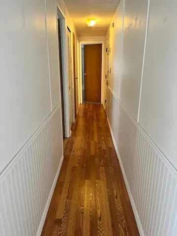a view of a hallway with wooden floor