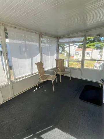 a room with a balcony a bed and a large window