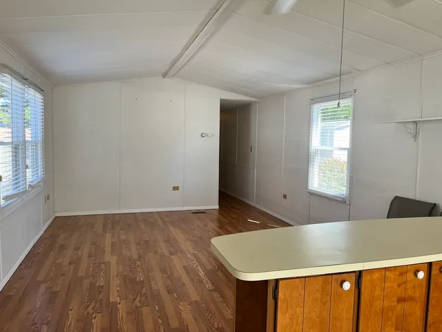 a view of a room with wooden floor and window