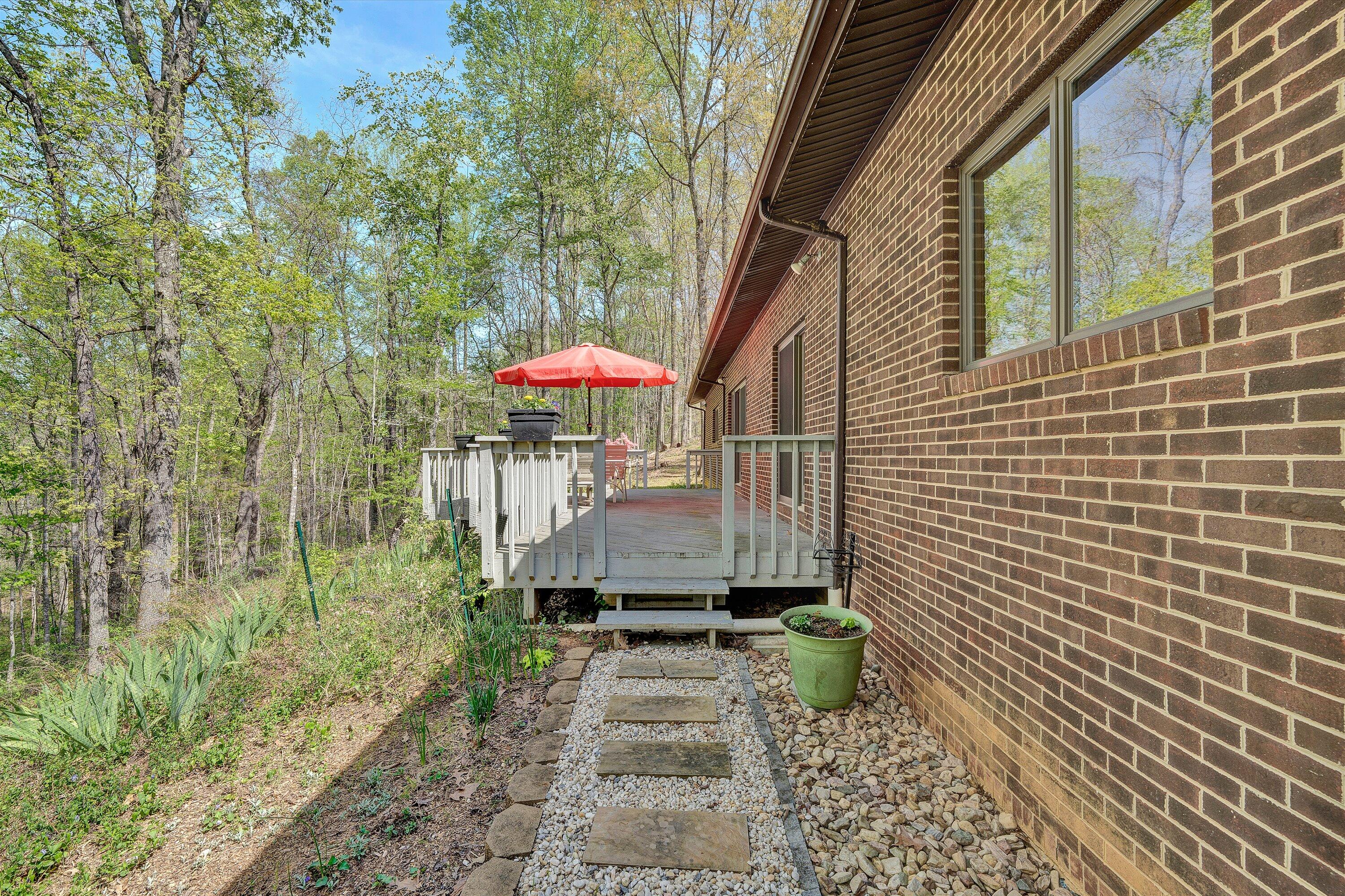 1124 Old Hollow Road Buchanan, VA 24066 - Photo 36 of 73 a view of a patio with table and chairs under an umbrella with large trees