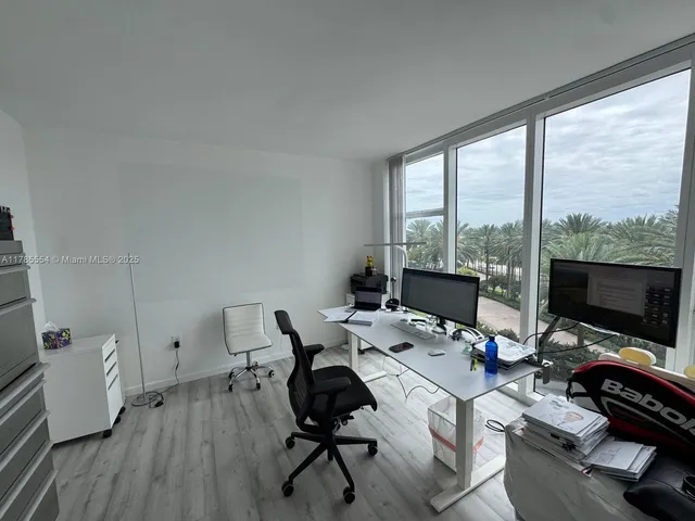 a view of a workspace with furniture and a flat screen tv