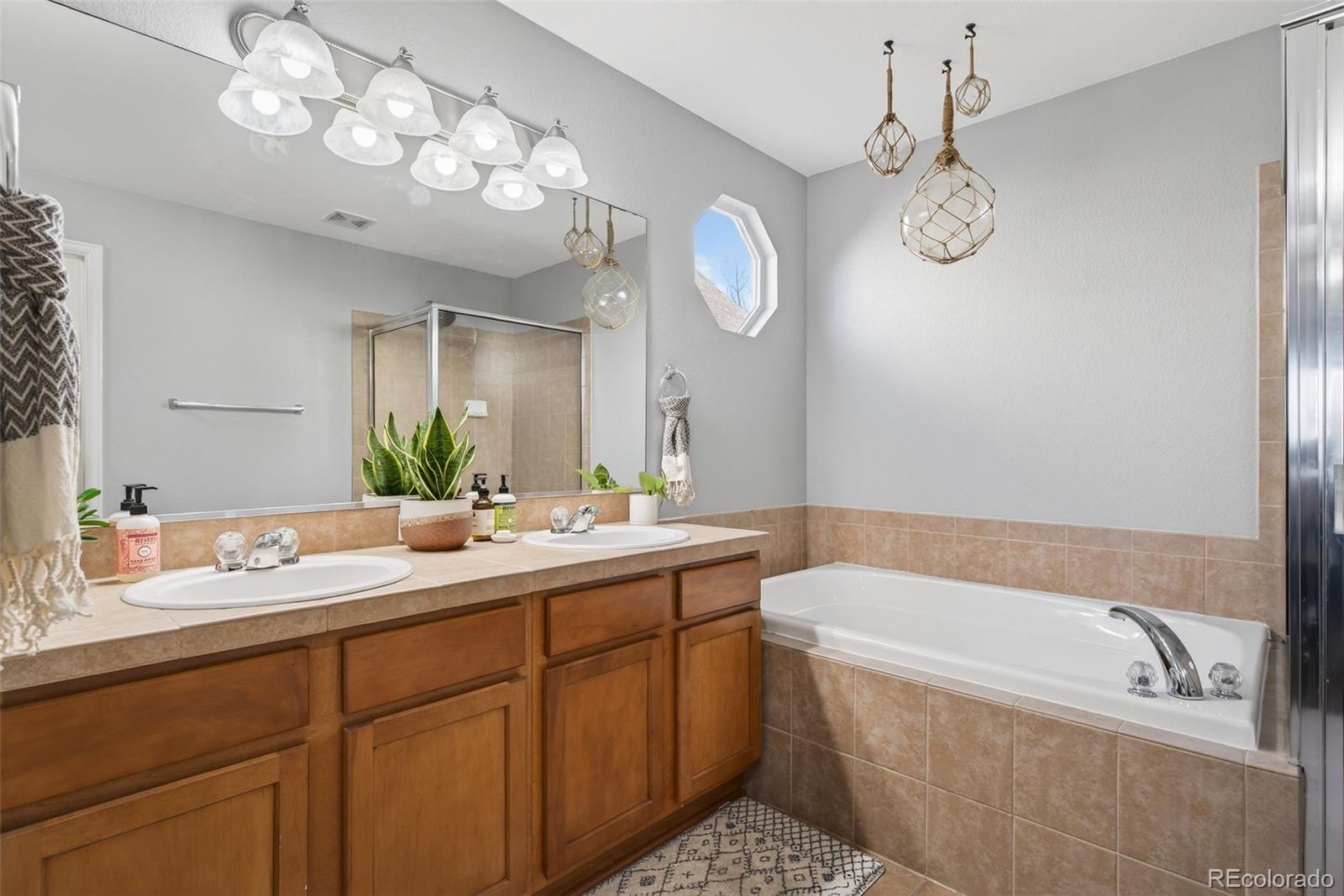 6737 Thistle Ridge Avenue Firestone, CO 80504 - Photo 17 of 39 a bathroom with a tub a sink and a mirror