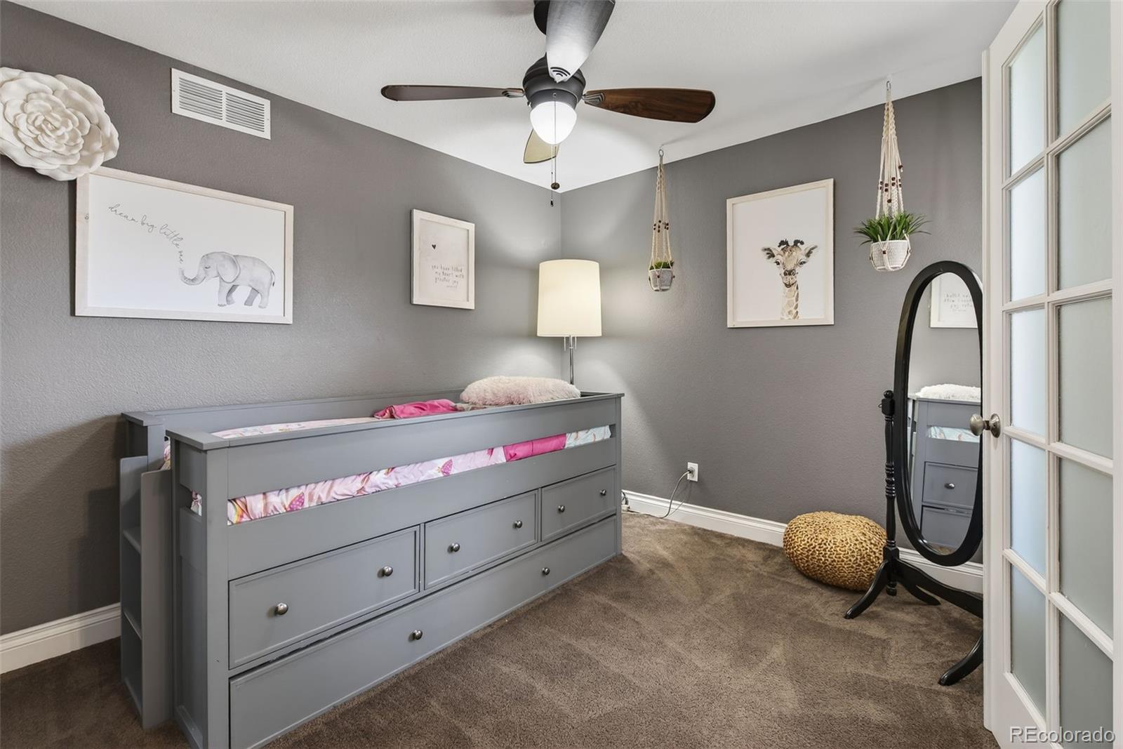 6737 Thistle Ridge Avenue Firestone, CO 80504 - Photo 19 of 39 a bedroom with a bed and a ceiling fan