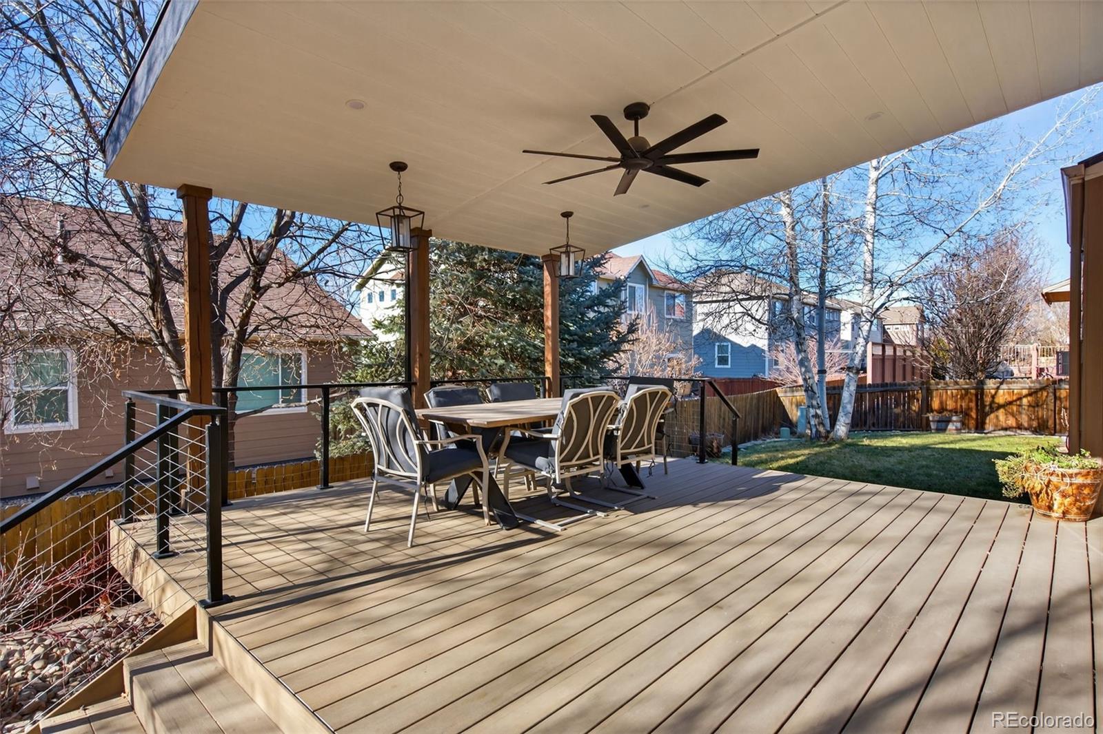6737 Thistle Ridge Avenue Firestone, CO 80504 - Photo 33 of 39 a view of a roof deck with table and chairs a barbeque with wooden floor and fence
