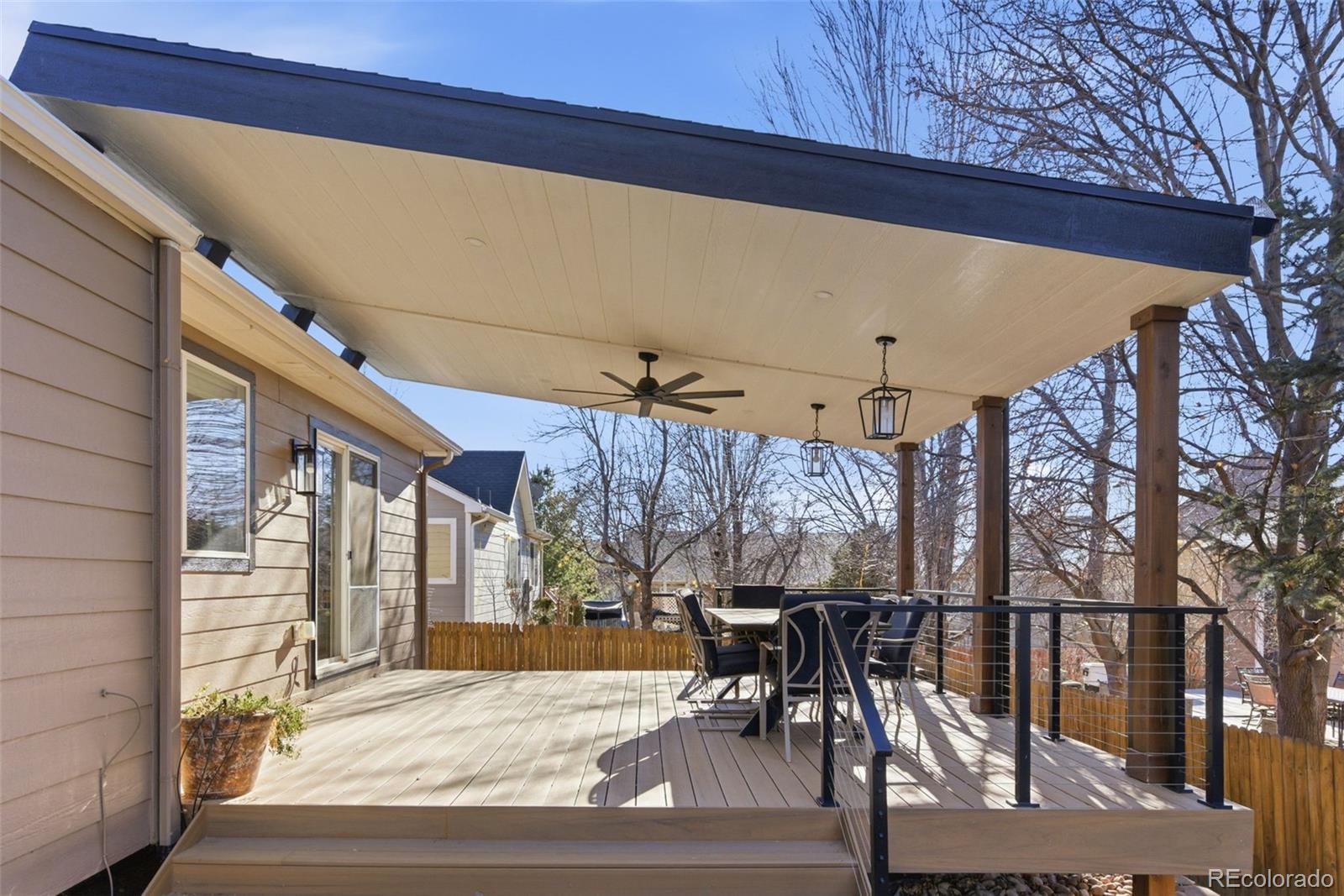 6737 Thistle Ridge Avenue Firestone, CO 80504 - Photo 36 of 39 a view of a patio with table and chairs with wooden floor and fence