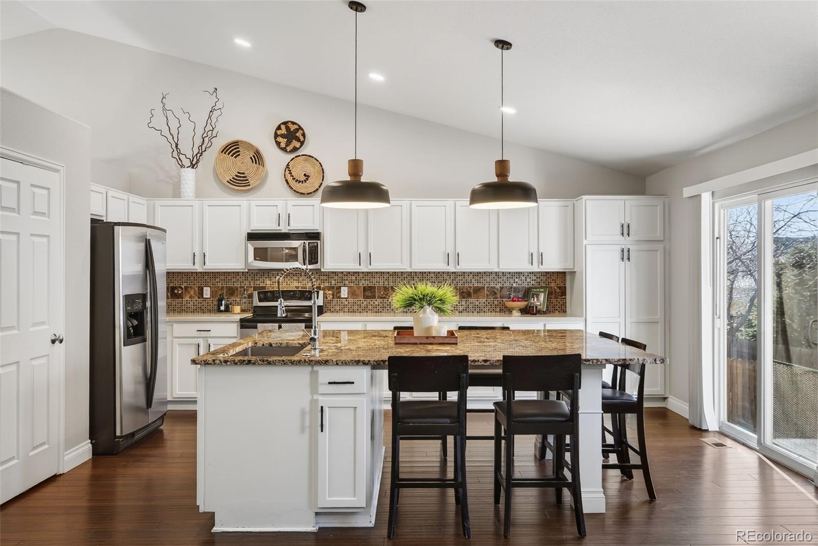 6737 Thistle Ridge Avenue Firestone, CO 80504 - Photo 6 of 39 a kitchen with stainless steel appliances granite countertop a sink a stove a refrigerator and wooden floor