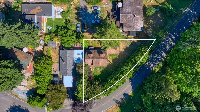 an aerial view of a house with a yard and lake view